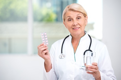 женщина-врач держит таблетки гормональной терапии