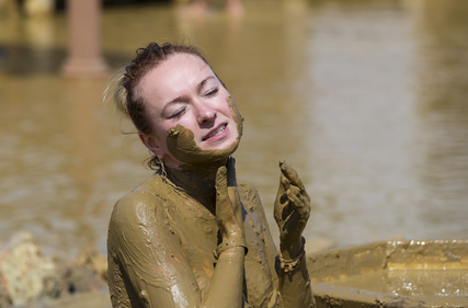женщина на мертвом море обмазывается грязью